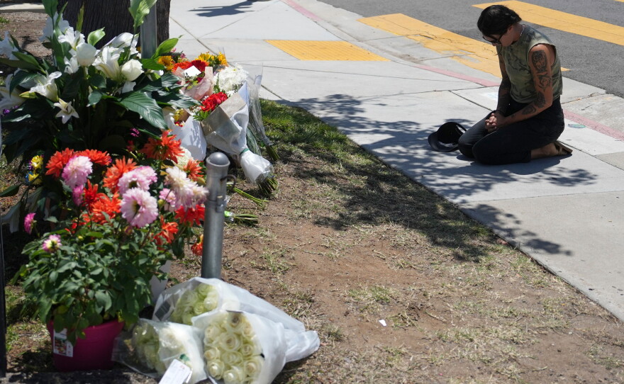 Nicole Witherow prays beside flowers placed outside of the Islamic Center of San Diego on May 19.