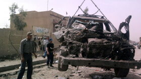 A vehicle is removed from the scene of a double-blast suicide bomb that targeted a military checkpoint in the former Sunni rebel bastion of Fallujah on Monday.