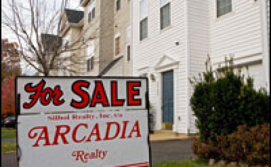 A "for sale" sign advertises that this townhouse in Virginia is in foreclosure.