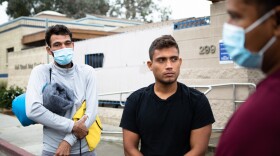 Men from Venezuela wait outside of a homeless shelter in San Diego, Oct. 5, 2022. The group first stayed at a shelter run by Catholic Charities after they were allowed to enter the United States but are now looking for work and living on the street.