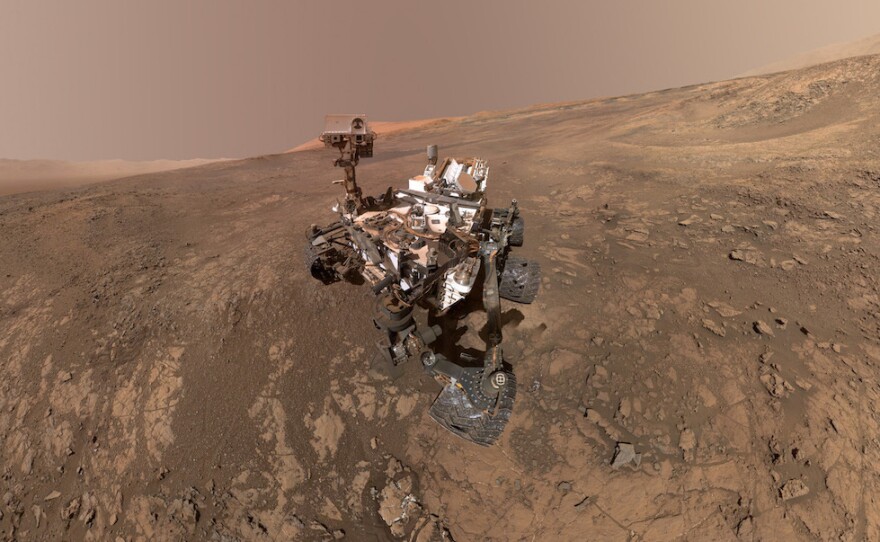 NASA's rover Curiosity crawls up the side of Vera Rubin Ridge on Mars' surface in January 2018. Mount Sharp — a 3-mile-high mountain — can be seen in the distance.