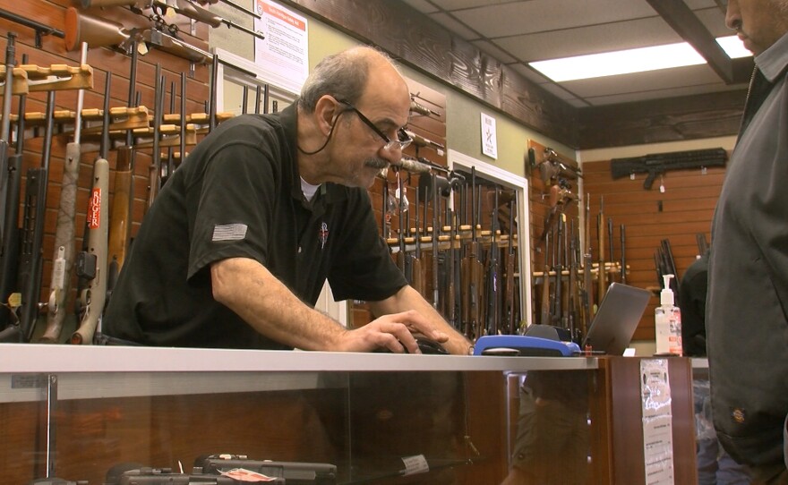 A customer looks at guns inside AO Sword Firearms in El Cajon, March 23, 2020.