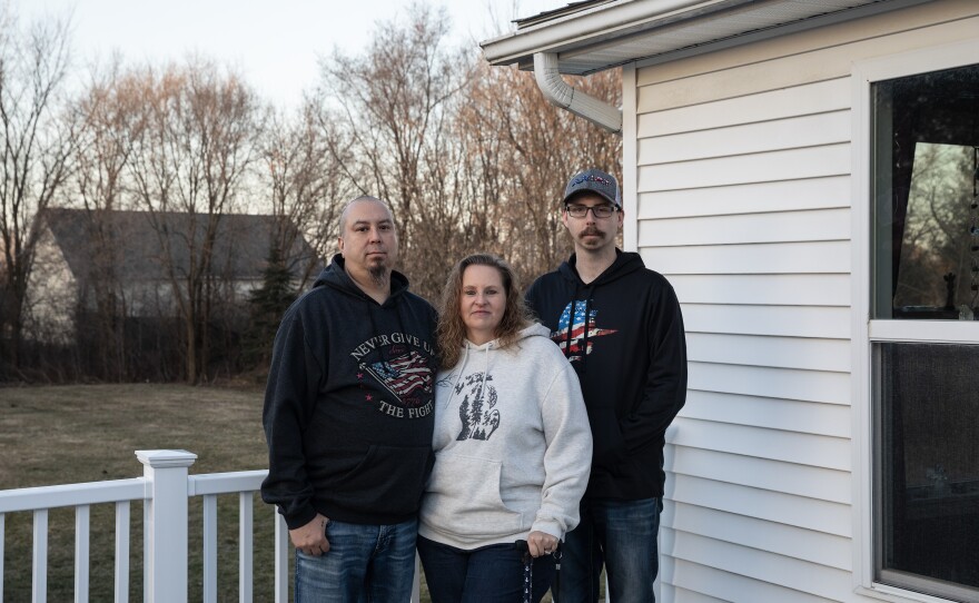 Matt Zissler, Shelly Zissler and her son, Matt Vaughn, who all work for General Motors' Flint Assembly plant, pose for a portrait outside their home in Flint, Mich., on Saturday.