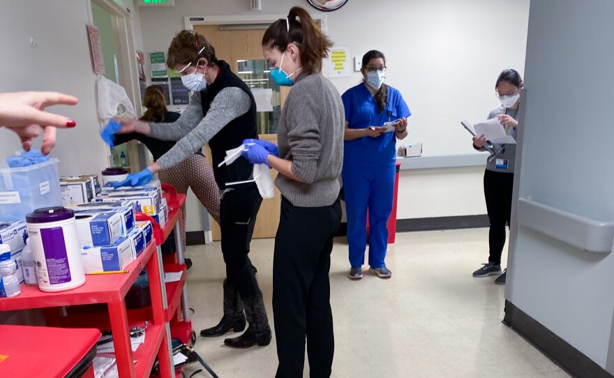 The flood of COVID cases at Harborview Medical Center adds to the workload of nursing and medical staff, who must pick up duties like cleaning room and delivering meals to lessen the number of people exposed to the virus.
