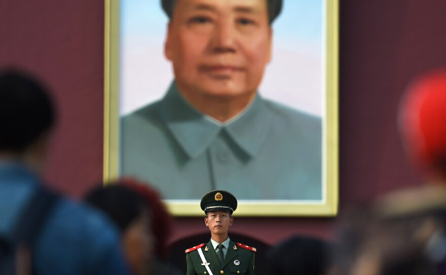 Visitors walk past a portrait of late communist leader Mao Zedong on Tiananmen Gate in Beijing on Sept. 30, the eve of National Day.