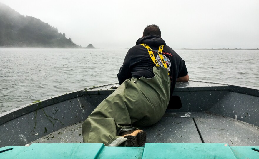 Jerome Nick Jr. perches in the front of the boat, checking to see if any Yurok tribal members are fishing.