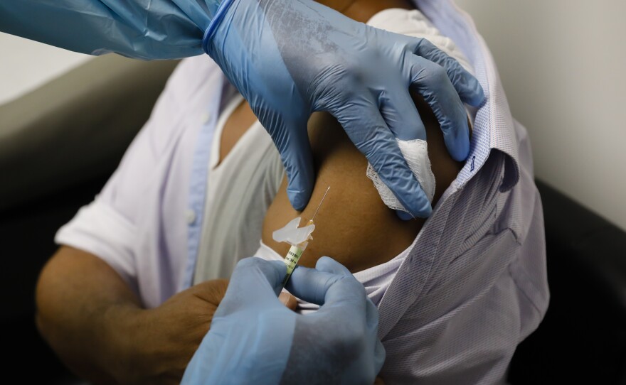 A volunteer in a clinical trial for an experimental COVID-19 vaccine receives an injection at Research Centers of America in Hollywood, Fla., in early September.