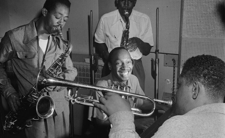 Tadd Dameron (smiling at center) was an important figure in American jazz and bebop. He is shown here with Fats Navarro on trumpet, and Charlie Rouse and Ernie Henry on saxophone.