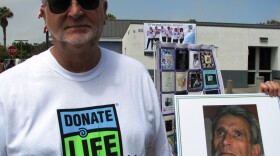 San Diegan Michael McCrerey holding a picture of himself when he was dying of liver disease. He’s alive today because he received a liver from a man who signed up to become an organ donor. 