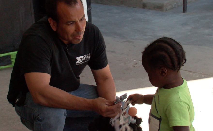 Hugo Castro, volunteer coordinator at Border Angels, plays with a Haitian child in Tijuana, March 16, 2017.