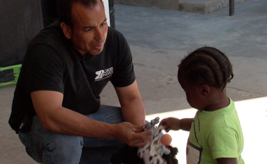 Hugo Castro, volunteer coordinator at Border Angels, plays with a Haitian child in Tijuana, March 16, 2017. 