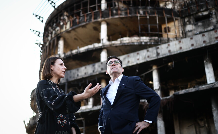 Britain's Prime Minister Andy Burnham reacts as he is shown the rubbles and wreckages left on the buildings and site of a strike by the Lukanivska market in  Kyiv, Monday, Aug. 24, 2026.