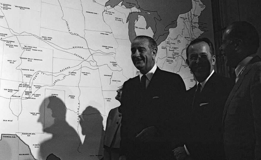 President Lyndon Johnson stands near a map of the U.S. after signing several conservation bills into law in 1968. He signed the landmark National Historic Preservation Act two years earlier.