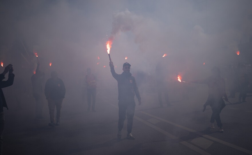 Protesters march with flares during a demonstration in Marseille, southern France, on Tuesday. France's government is unfurling massively ramped-up security measures for a fresh blast of marches and strikes against unpopular pension reforms.
