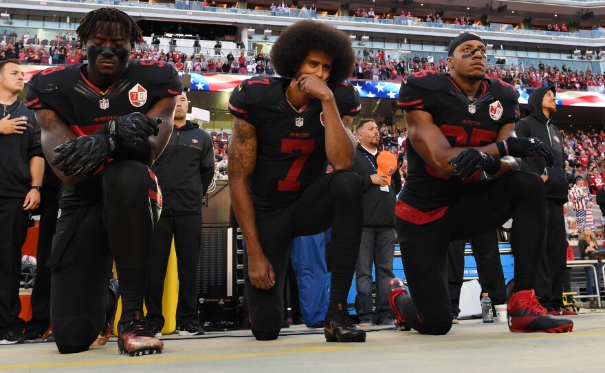 Eli Harold (from left), Colin Kaepernick and Eric Reid of the San Francisco 49ers kneel in protest during the national anthem prior to a game against the Arizona Cardinals at Levi's Stadium on Oct. 6, 2016, in Santa Clara, Calif.
