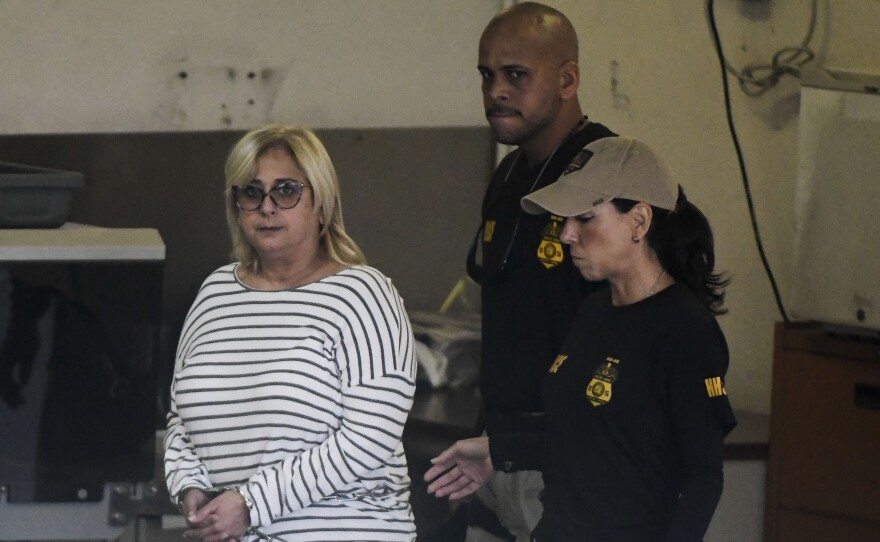 Federal agents escort former Puerto Rico Health Insurance Administration head Ángela Ávila-Marrero, who was arrested on Wednesday as part of a corruption investigation that resulted in an indictment against six defendants.