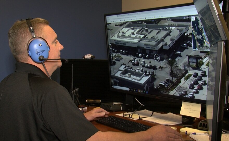A man wearing headphones controls a Chula Vista Police Department drone from a computer while sitting at a desk, Feb 5. 2020.