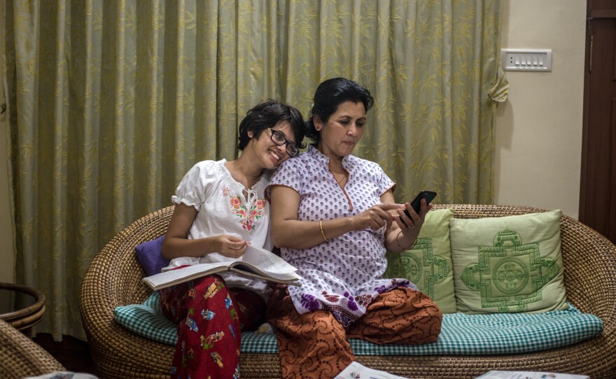 Prakriti Kandel and her mother look at pictures in their family album.