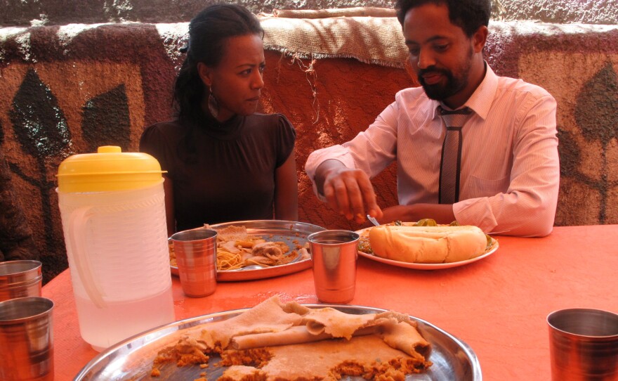 Customers enjoy a meal at Chef Cane's. He only serves one dish per day. Whatever the meal is, it's always served on top of a spongy sourdough flatbread called injera that doubles as a plate.