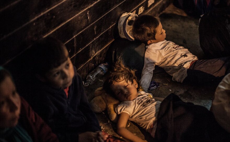 Afghan refugee family resting on the street in Athens, Greece. “Exodus” tells first-person stories of refugees and migrants fleeing war and persecution for Europe, drawing on footage filmed by the families themselves as they leave their homes on dangerous journeys seeking safety and refuge.