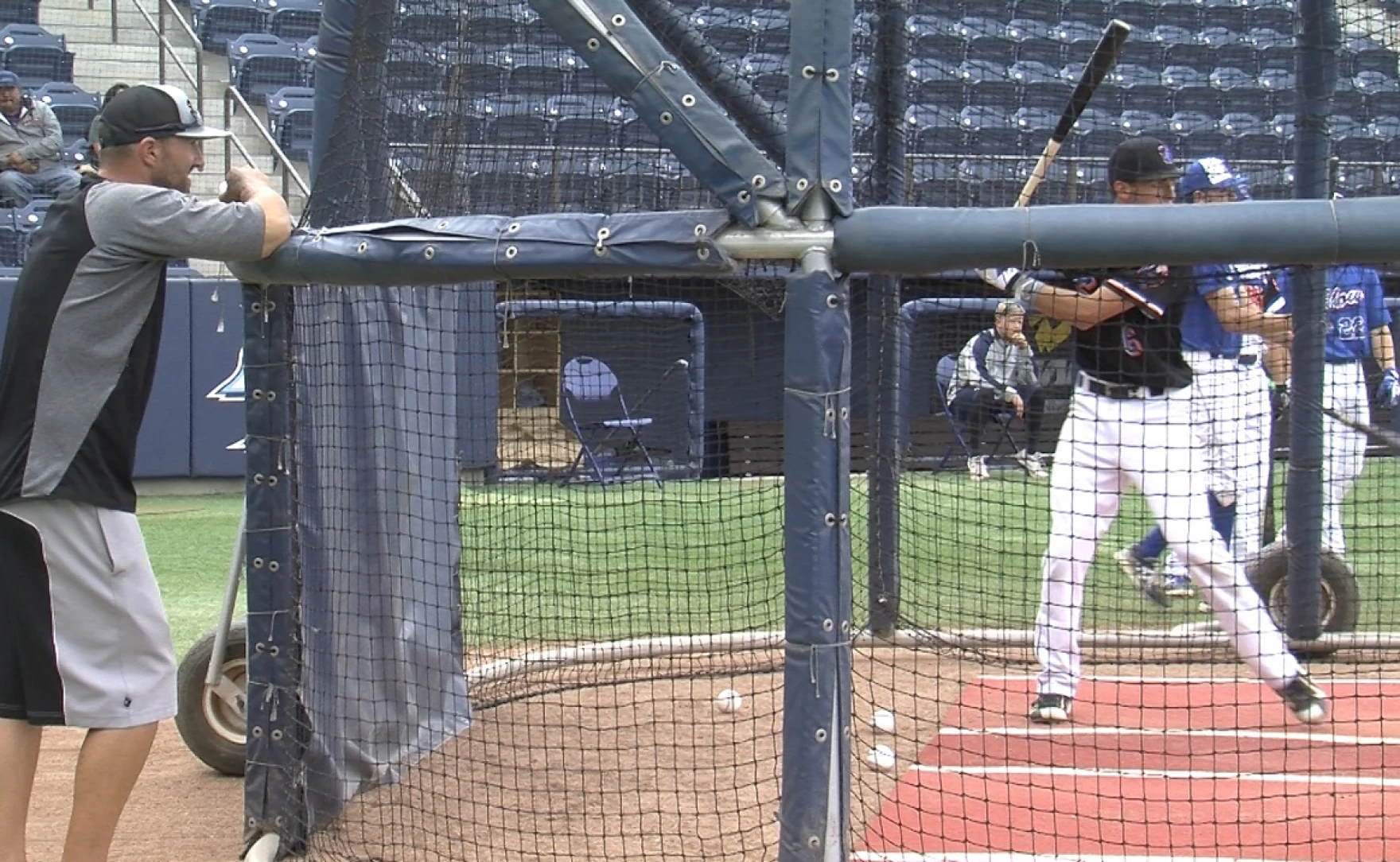 John Peabody (left) helps a player with his swing, June 9, 2016.