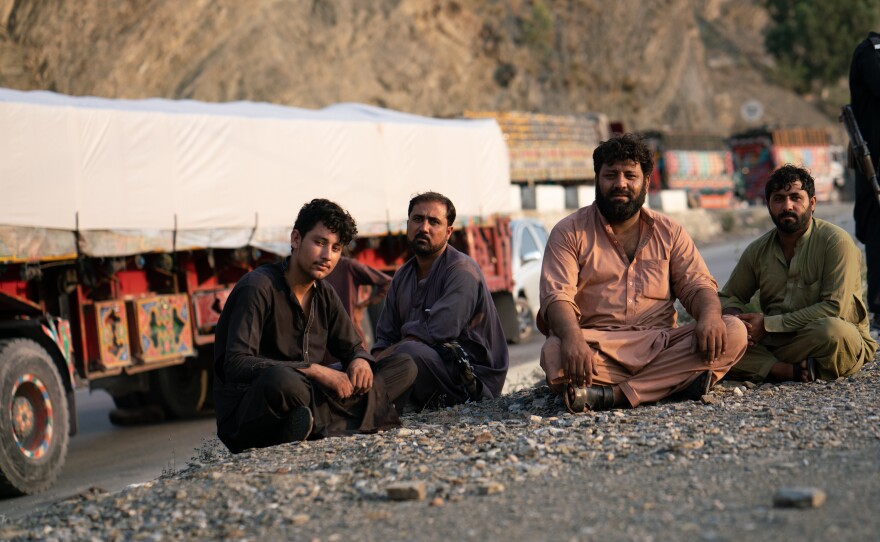 Razziq Mehmon (second from right) waits in Pakistan near the border to drive a truck loaded with cement bound for Jalalabad, Afghanistan.