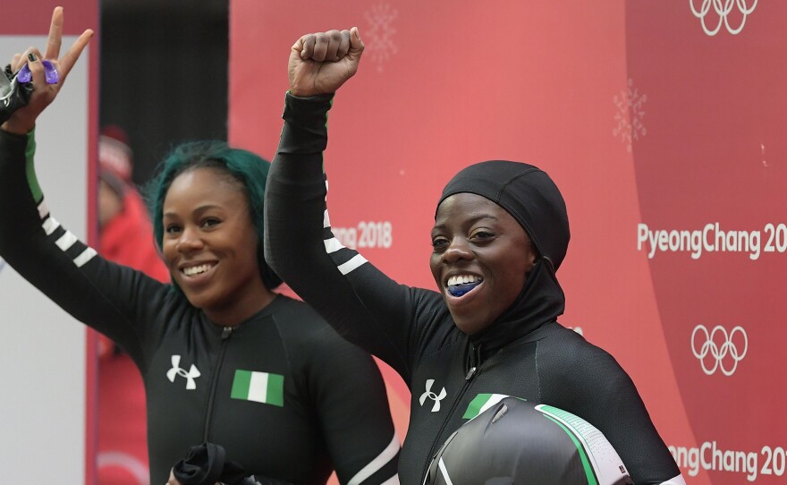Seun Adigun (right) and Akuoma Omeoga, from the Nigerian women's bobsled team, wave after an Olympic heat on February 20.