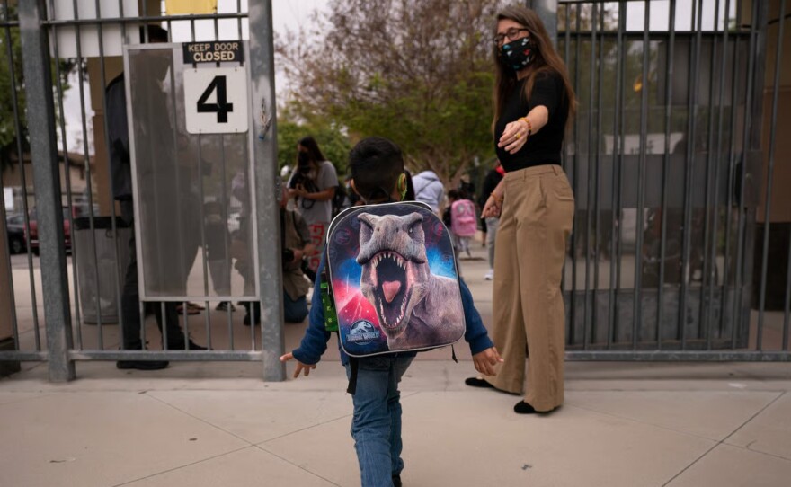 Kindergartener Angel Hernandez leaves after the first day of in-person learning at Maurice Sendak Elementary School in Los Angeles, Tuesday, April 13, 2021.