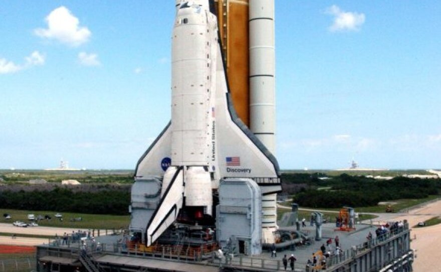 The crawler inches toward Launch Pad 39B at the Kennedy Space Center in 2005, traveling 1 mph and burning a gallon of gas every 32 feet. In 2005, its precious cargo was space shuttle Discovery; for its last trip at the end of May, the crawler will transport space shuttle Atlantis to its final launch.