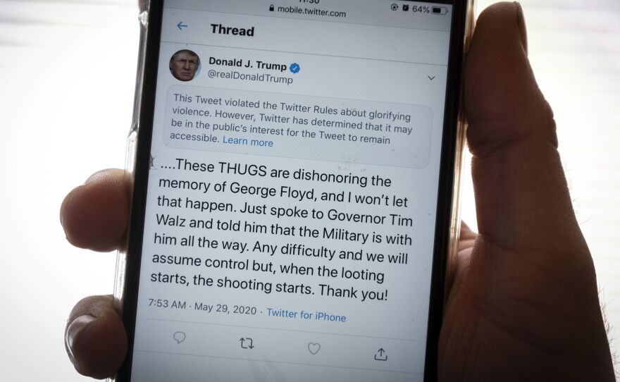 President Trump's Twitter page is displayed on a mobile phone. The social media company flagged one of his tweets about Minneapolis as "glorifying violence" and hid it from public view unless a user clicks on it.