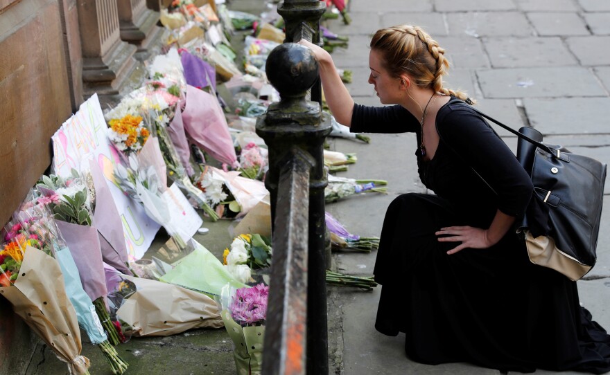 A woman lays flowers for the victims of the Manchester Arena attack in central Manchester on Tuesday.