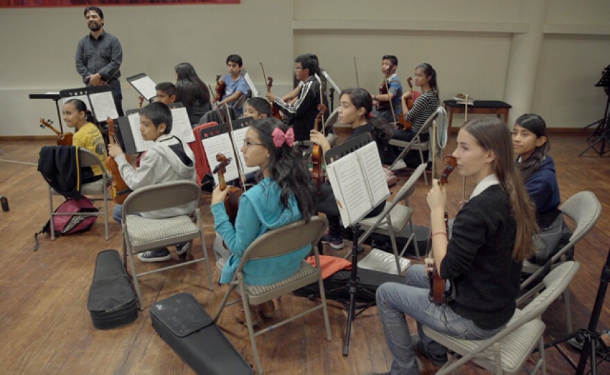 Children from the community learning how to play musical instruments.