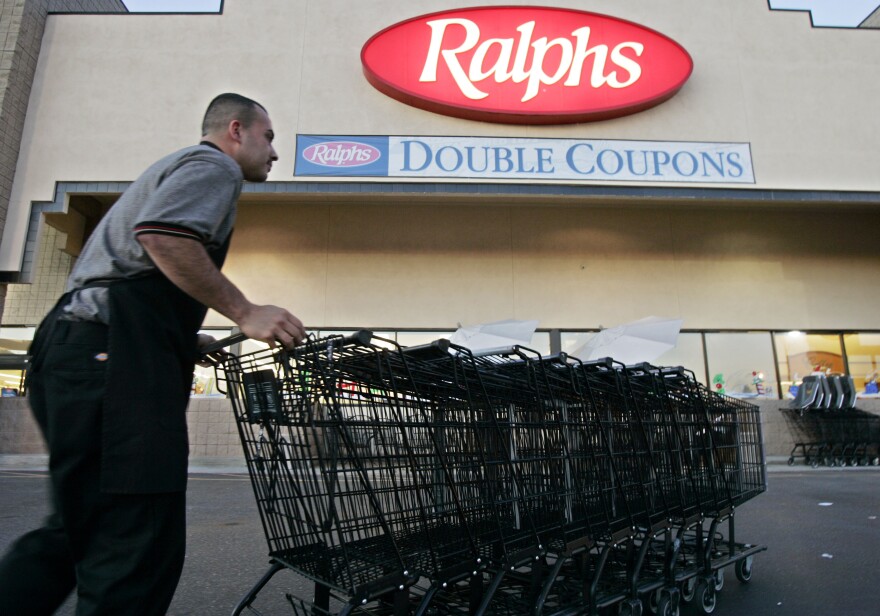 File photo of Francisco Luna collecting shopping carts outside of a Ralphs grocery store in Los Angeles on Monday, Dec. 5, 2005.