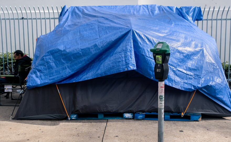 Jake, a homeless man, sits next to his tent on Eighth Ave between E and F street next to the post office in downtown San Diego, January 11, 2023.