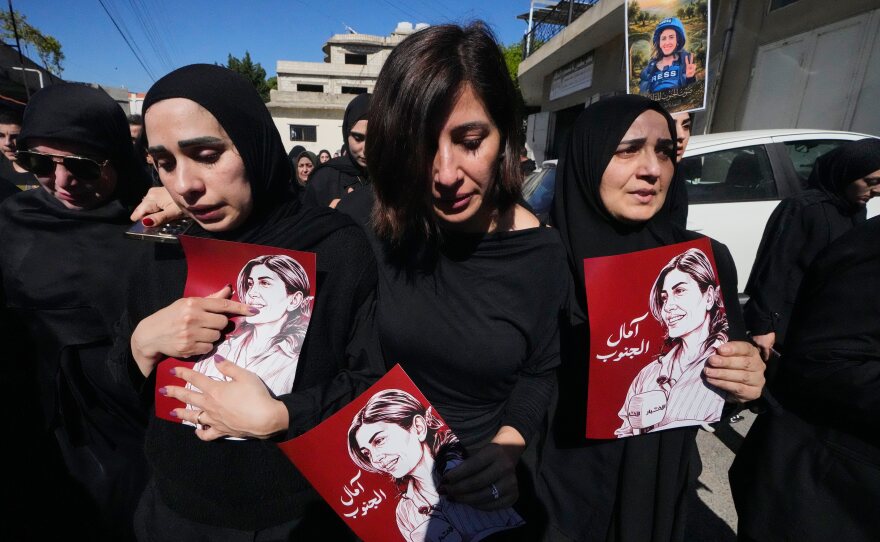 Mourners hold posters that show portraits of Lebanese journalist Amal Khalil, who was killed Wednesday in an Israeli airstrike, during her funeral procession in the village of Baysariyeh, in southern Lebanon, on Thursday.