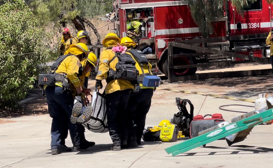 Firefighters practice helping one of their own during the San Diego Multi Agency Wildfire Preparedness Exercise in Valley Center.