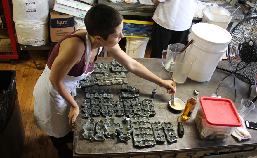 Candy maker Mariel Celentano oils the molds to prevent the candy mixture from sticking.