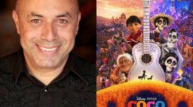 Herbert Siguenza, co-founder of the Latino performance troupe, Culture Clash, next to movie poster of Pixar's animated film, "Coco."