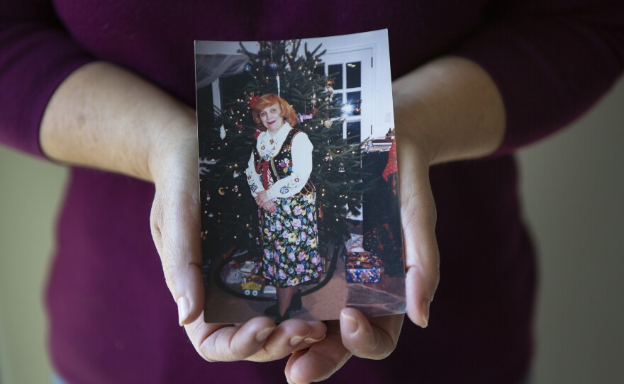 Cassaro holds a photograph of her mother. "My mom died among strangers," she said.