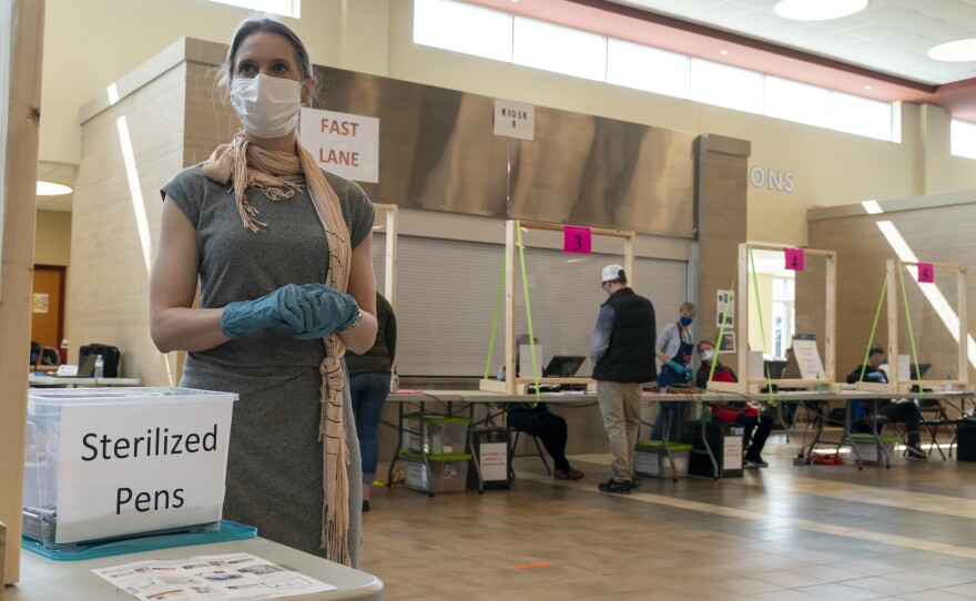 A poll worker in Sun Prairie, Wis., is seen during the state's April 7 primary. A record number of Wisconsin voters are expected to vote by mail this fall, but polls indicate Republicans are far more likely to vote in person, which has some GOP officials worried it could hurt the party's chances.