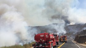 Fire trucks working to extinguish flames from the Pasqual Fire in San Pasqual Valley, July 26, 2018. 