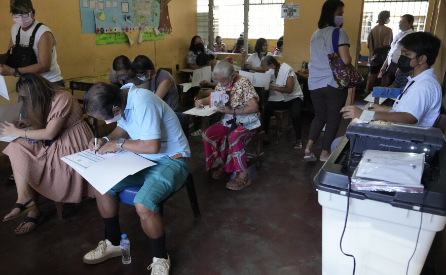 People vote at a school used as a polling center Monday, in Quezon City, Philippines.