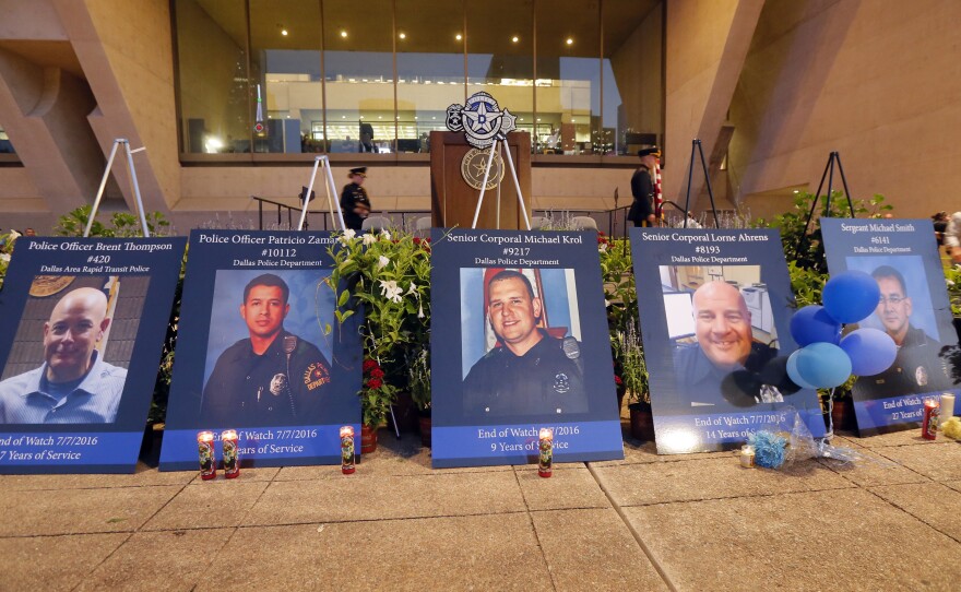 Portraits of the five murdered Dallas police officers sit in front of city hall.