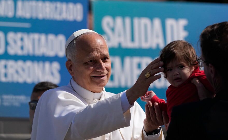 Pope Leo XIV blesses a child during a meeting with migrants at the "Las Raices" center, in San Cristobal de la Laguna in Spain.