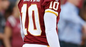 Washington Redskins quarterback Robert Griffin III watches from the sidelines. RG3 as he is known has a fan in other thirds like Frank Deford.