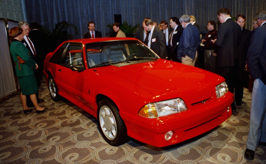 Reporters look over the limited edition 1993 Ford Mustang Cobra after its unveiling Feb. 6, 1992, in Chicago. This was part of the third generation of Mustangs that were produced from 1979 to 1993.