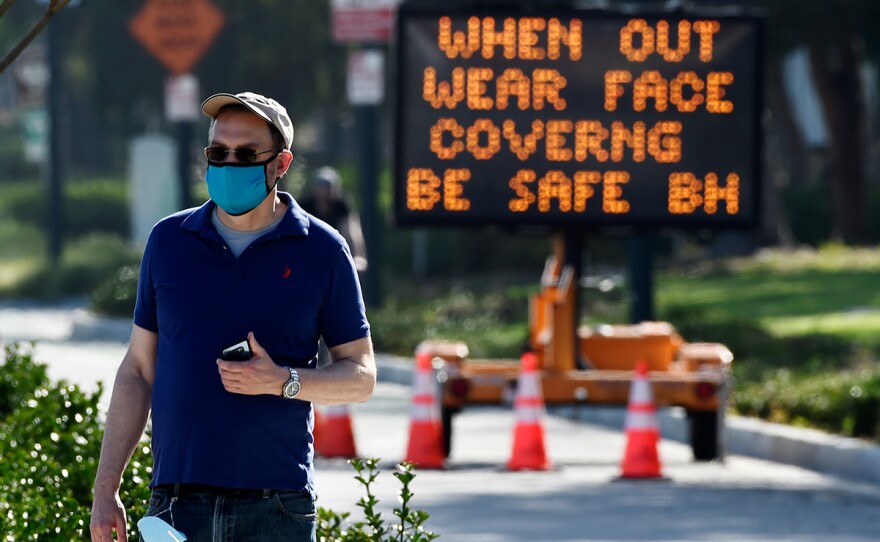 An electronic sign on Santa Monica Boulevard reminds people to wear masks to limit the spread of coronavirus, Thursday, April 16, 2020, in Beverly Hills, Calif.