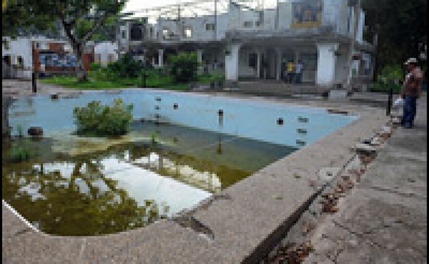 Visitors look at Escobar's swimming pool and destroyed mansion at Hacienda Napoles.