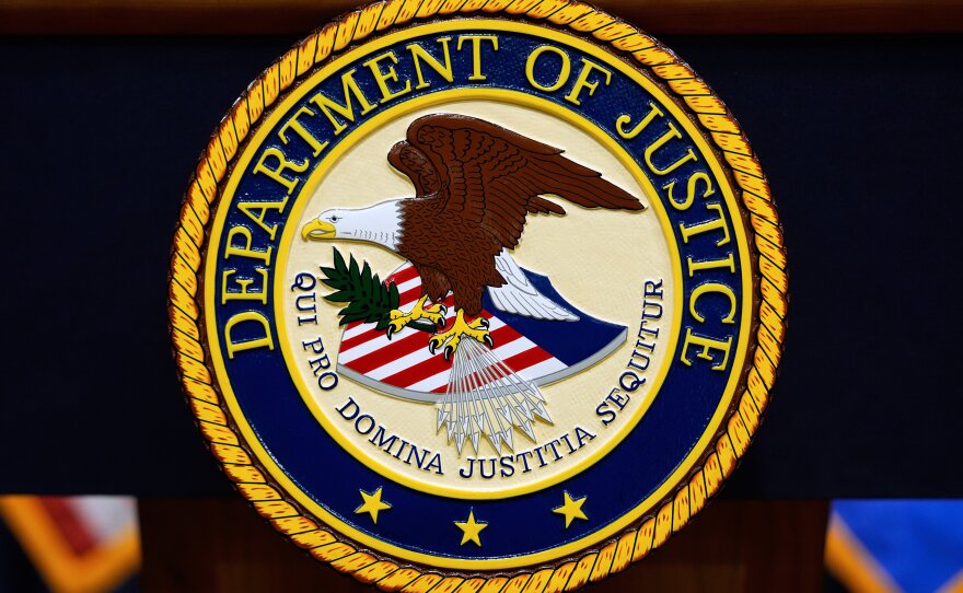 The U.S. Department of Justice logo is seen on a podium before a news conference at the Justice Department in Washington, on May 6, 2025.