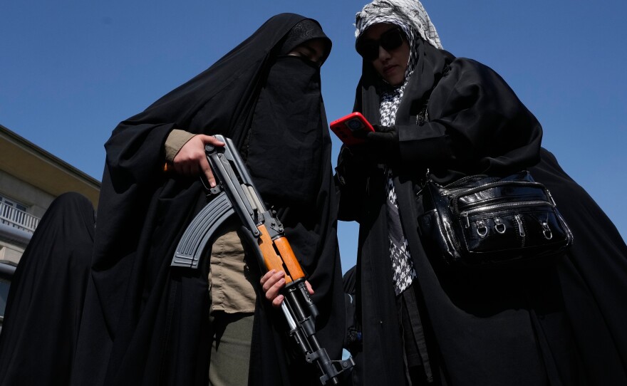 A woman member of the Basij paramilitary, affiliated with Iran's Revolutionary Guard, holds her gun during a state-organized rally in support of the supreme leader marking National Girl's Day in Tehran, Iran, Friday, April 17, 2026.
